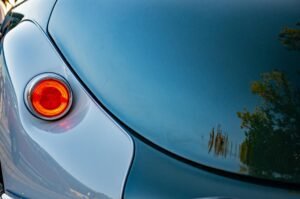 Close-up of a vintage car tail light reflecting surroundings in Ingolstadt, Germany.